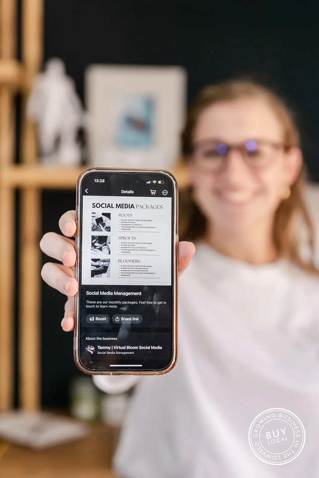 Picture of Melissa holding a phone displaying Virtual Bloom's digital service brochure