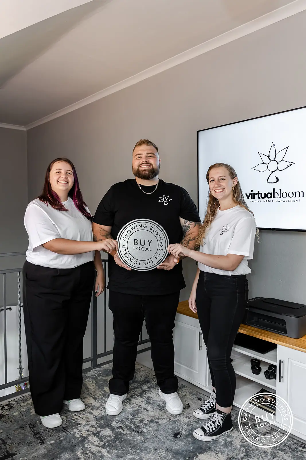 Tammy, Shandon, and Melissa holding the Buy Local Lowveld logo